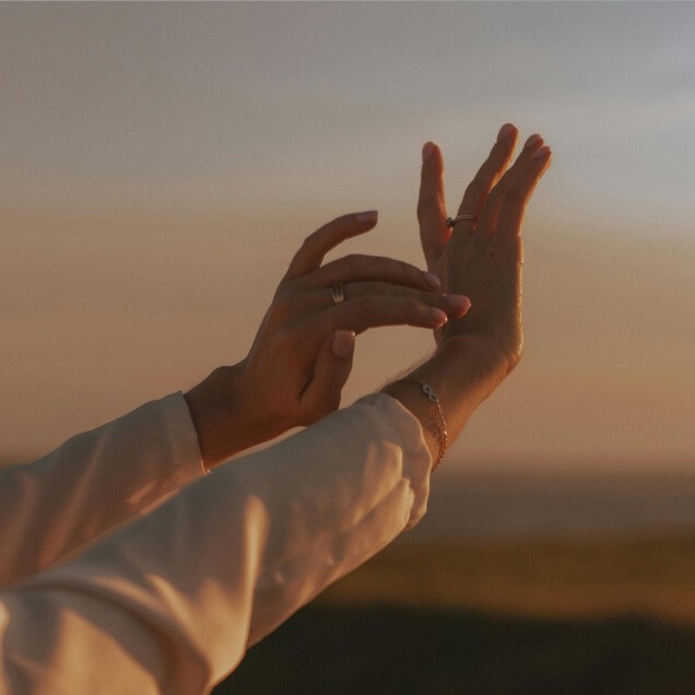 Hands reaching to sunset